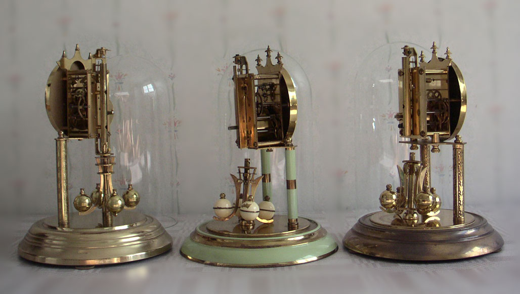 Three German clocks with a ball pendulum